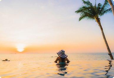 Kobieta w infinity pool o zachodzie słońca